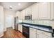Bright kitchen with white cabinets, stainless steel appliances, black countertops, and wood flooring at 487 Foxhill Dr, Debary, FL 32713