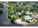 Aerial view of resort-style pool, tennis courts, parking, sandy beach and lake surrounded by mature trees at 5154 Majestic Woods Pl, Sanford, FL 32771