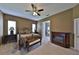 Cozy main bedroom featuring a fireplace, ceiling fan, and neutral decor at 5154 Majestic Woods Pl, Sanford, FL 32771