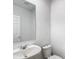Compact half-bathroom featuring a pristine white sink, toilet, and a large mirror for added convenience at 596 Sun Warbler Way, St Cloud, FL 34771