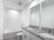 Bright bathroom with double sink vanity, granite countertop, white cabinets, and tiled shower/tub at 596 Sun Warbler Way, St Cloud, FL 34771