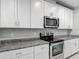 Well-appointed kitchen with white cabinets, stainless steel appliances, and granite countertops, offering style and functionality at 596 Sun Warbler Way, St Cloud, FL 34771