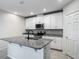 Bright kitchen with white cabinets, granite countertops, stainless steel appliances, and a center island with a sink at 596 Sun Warbler Way, St Cloud, FL 34771