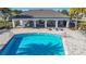 An aerial view of the community pool and covered pavilion, complete with tables, chairs, and lush landscaping at 596 Sun Warbler Way, St Cloud, FL 34771