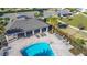 Aerial view of the sparkling community pool and covered pavilion with lounge chairs, surrounded by lush landscaping at 596 Sun Warbler Way, St Cloud, FL 34771