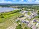 Aerial view of a modern community featuring homes with solar panels and private pools near a tranquil pond at 5967 Churchill Square Way, Groveland, FL 34736