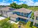 Aerial view of a blue house with a landscaped yard, brown roof, and neighborhood at 5967 Churchill Square Way, Groveland, FL 34736