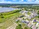 Targeted aerial view of a modern community home, featuring solar panels and a private pool, near a tranquil pond at 5967 Churchill Square Way, Groveland, FL 34736