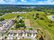 Neighborhood aerial view of homes near farmland and a body of water at 5967 Churchill Square Way, Groveland, FL 34736