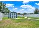 Fenced in backyard featuring grass, a storage shed and playground area at 5967 Churchill Square Way, Groveland, FL 34736