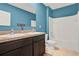 Bright bathroom with double vanity, tile floors, and blue accent wall at 5967 Churchill Square Way, Groveland, FL 34736