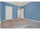 Bedroom with blue walls features neutral carpet and white trim at 5967 Churchill Square Way, Groveland, FL 34736