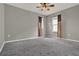 Bedroom featuring neutral walls, gray carpet, a ceiling fan and curtained windows at 5967 Churchill Square Way, Groveland, FL 34736