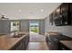 Kitchen with dark cabinets, an island, stainless appliances and view to backyard at 5967 Churchill Square Way, Groveland, FL 34736