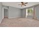Large main bedroom featuring a ceiling fan, neutral carpet, and a backyard view at 5967 Churchill Square Way, Groveland, FL 34736