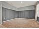 Room featuring gray walls with paneling, neutral carpet, and a bright window with floral curtains at 5967 Churchill Square Way, Groveland, FL 34736