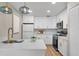 Modern kitchen with white cabinets, quartz countertops, stainless steel appliances, and stylish pendant lights at 614 Plum Ln, Altamonte Springs, FL 32701