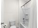 Clean bathroom featuring a shower-tub combo with white tile surround and a efficient toilet, ready for personal touches at 616 Griffon Ave, Lake Alfred, FL 33850
