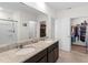 Bathroom features a dual sink vanity with granite countertops and walk-in closet at 616 Griffon Ave, Lake Alfred, FL 33850