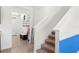 The home's staircase is seen from the entryway, accented with neutral and blue hues at 616 Griffon Ave, Lake Alfred, FL 33850