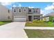 Inviting two-story home with a well-manicured lawn, two-car garage, and a covered front porch at 616 Griffon Ave, Lake Alfred, FL 33850