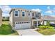 Beautiful shot of a two-story residential home featuring an attached two-car garage at 616 Griffon Ave, Lake Alfred, FL 33850