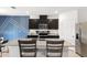 Spacious kitchen with dark cabinets, granite countertops, stainless appliances, and an island with barstool seating at 616 Griffon Ave, Lake Alfred, FL 33850
