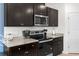 Well-equipped kitchen featuring granite countertops, dark cabinets, and stainless steel appliances at 616 Griffon Ave, Lake Alfred, FL 33850