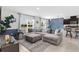 Spacious living room featuring a sectional sofa, tiled floors, and stylish blue accent wall at 616 Griffon Ave, Lake Alfred, FL 33850