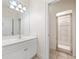 Bathroom with white vanity and mirror with shower in the next room, separated by a glass door at 6161 Blakeford Dr, Windermere, FL 34786