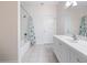 Bathroom with neutral tile flooring features white vanity and shower/tub combo with shower curtain at 6161 Blakeford Dr, Windermere, FL 34786