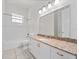 Bathroom features granite-topped vanity, neutral-toned tile floor and a tub with white tile surround at 6161 Blakeford Dr, Windermere, FL 34786
