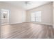 Spacious bedroom with wood-look flooring, a window with blinds, and an adjoining bathroom at 6161 Blakeford Dr, Windermere, FL 34786
