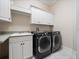 Well-equipped laundry room with modern washer and dryer and white cabinetry for ample storage at 6161 Blakeford Dr, Windermere, FL 34786