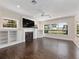 Bright living room with hardwood floors, built-in shelving, and large windows offering natural light at 6161 Blakeford Dr, Windermere, FL 34786
