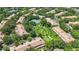 An aerial shot of the villa community boasting lush green spaces, mature trees, and a tennis court at 6205 Miramonte Dr # 103, Orlando, FL 32835
