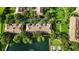 Aerial view of a lakefront community featuring lush landscaping, a pool, and well-maintained buildings at 6205 Miramonte Dr # 103, Orlando, FL 32835