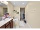 Bright bathroom featuring a soaking tub, double vanity and decorative shelving for storage at 6205 Miramonte Dr # 103, Orlando, FL 32835