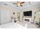 Comfortable bedroom featuring a fireplace, a ceiling fan, and a decorative mirror at 6205 Miramonte Dr # 103, Orlando, FL 32835