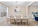 Elegant dining room with a white table, seating for eight, stylish chandelier, and bright window at 6205 Miramonte Dr # 103, Orlando, FL 32835