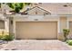Beige two-car garage door with brick-paved driveway leading up to it at 6205 Miramonte Dr # 103, Orlando, FL 32835