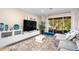 Elegant living area with a modern entertainment unit, cozy seating, and sliding doors to the screened-in patio at 6205 Miramonte Dr # 103, Orlando, FL 32835