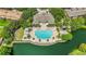 Aerial view of large community pool, clubhouse, and lake showcasing beautiful outdoor recreation area at 6205 Miramonte Dr # 103, Orlando, FL 32835