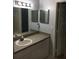 Neutral bathroom featuring a speckled vanity countertop, mirrored medicine cabinet, and a framed mirror at 6304 Raleigh St # 204, Orlando, FL 32835