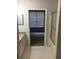 Bathroom view into bedroom with neutral carpet and a window with window blinds at 6304 Raleigh St # 204, Orlando, FL 32835