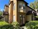 Corner unit exterior with double doors, manicured landscaping, and natural light at 6304 Raleigh St # 204, Orlando, FL 32835