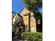 Two-story townhome with a yellow exterior, dark roof, and a well-maintained green hedge in front at 6304 Raleigh St # 204, Orlando, FL 32835