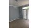 Cozy living room with carpeted floors and sliding glass doors to the exterior at 6304 Raleigh St # 204, Orlando, FL 32835