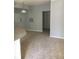 Bright living area with neutral gray walls, carpet, and a view into the kitchen at 6304 Raleigh St # 204, Orlando, FL 32835