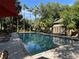Community pool area with palm trees, lounge chairs and lush landscaping creating a serene, resort-like atmosphere at 6304 Raleigh St # 204, Orlando, FL 32835